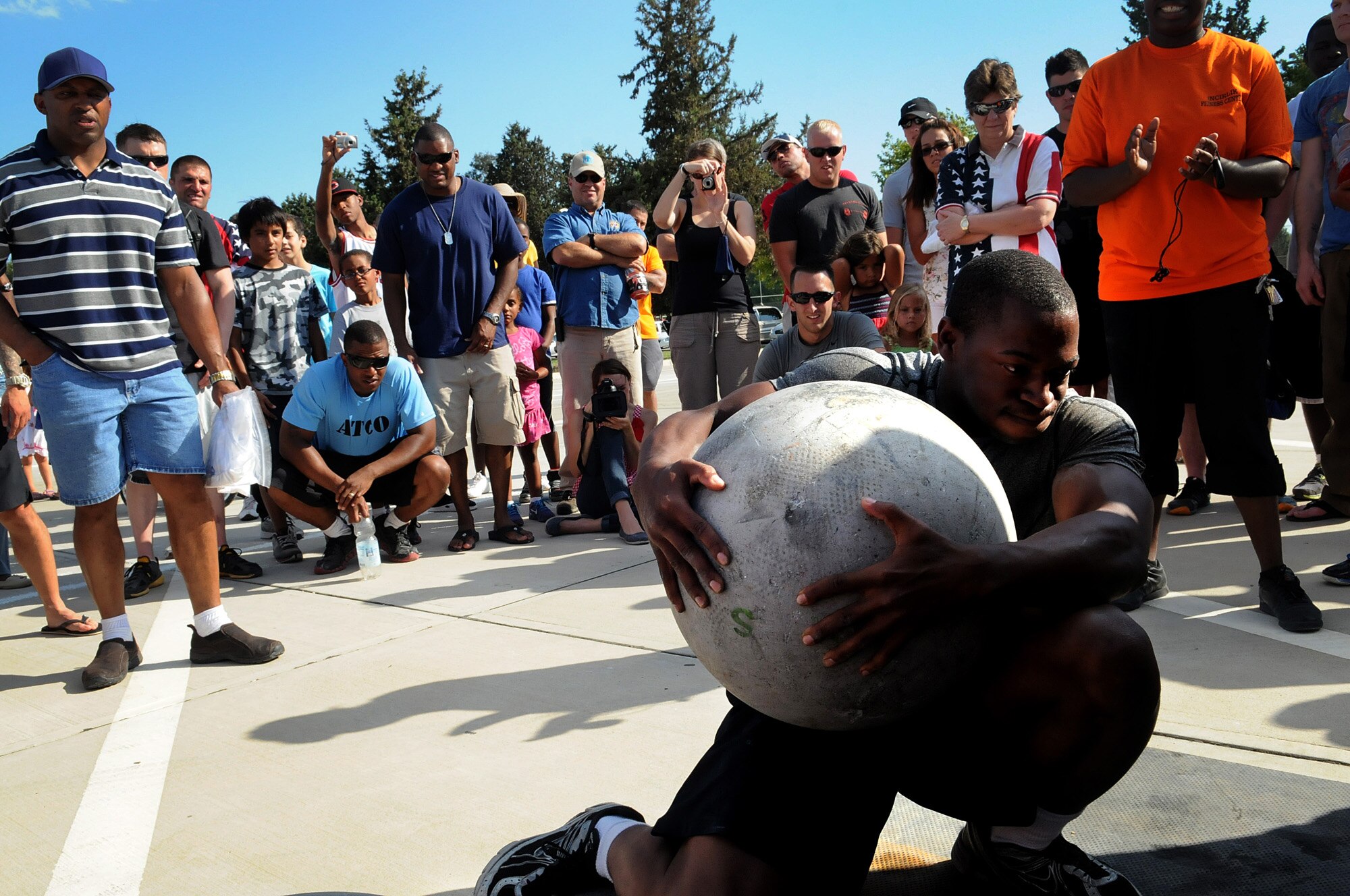 Airman 1st Class William Jones, 39th Maintenance Squadron, attempts to lift a 200-pound boulder onto a platform during the Strongman Competition July 4, 2012, at Incirlik Air Base, Turkey. Jones placed third in the competition, which tested physical strength using a series of heavy-lifting events. The competition was part of the Independence Day activities sponsored by the 39th Force Support Squadron and was followed by a concert and fireworks. (U.S. Air Force photo by Senior Airman Marissa Tucker/Released)