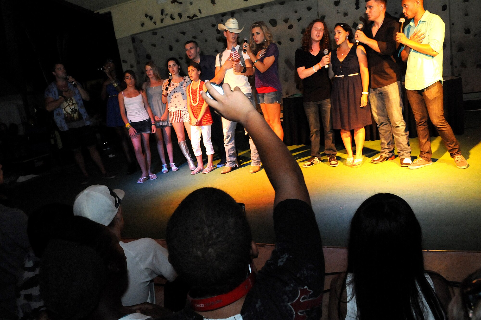 Members of the American Idol Tour and members of Team Incirlik sing the National Anthem before a fireworks display during the Independence Day celebration July 4, 2012, at Incirlik Air Base, Turkey. The Idols Tour visit was sponsored by Armed Forces Entertainment. (U.S. Air Force photo by Senior Airman Marissa Tucker/Released)