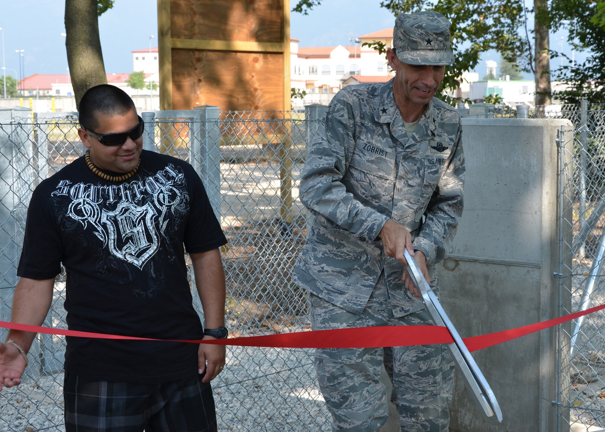 Brig. Gen. Scott Zobrist, 31st Fighter Wing commnader, and Staff Sgt. Andres Moreno-Rojas, dog park volunteer maintainer, of the Aviano Dog Park July 4, 2012.  The quality-of-life initiative was put into action after requests came through town hall meetings, the interactive customer evaluation system and spouse network channels. (U.S. Air Force photo/Capt. Erick Saks)