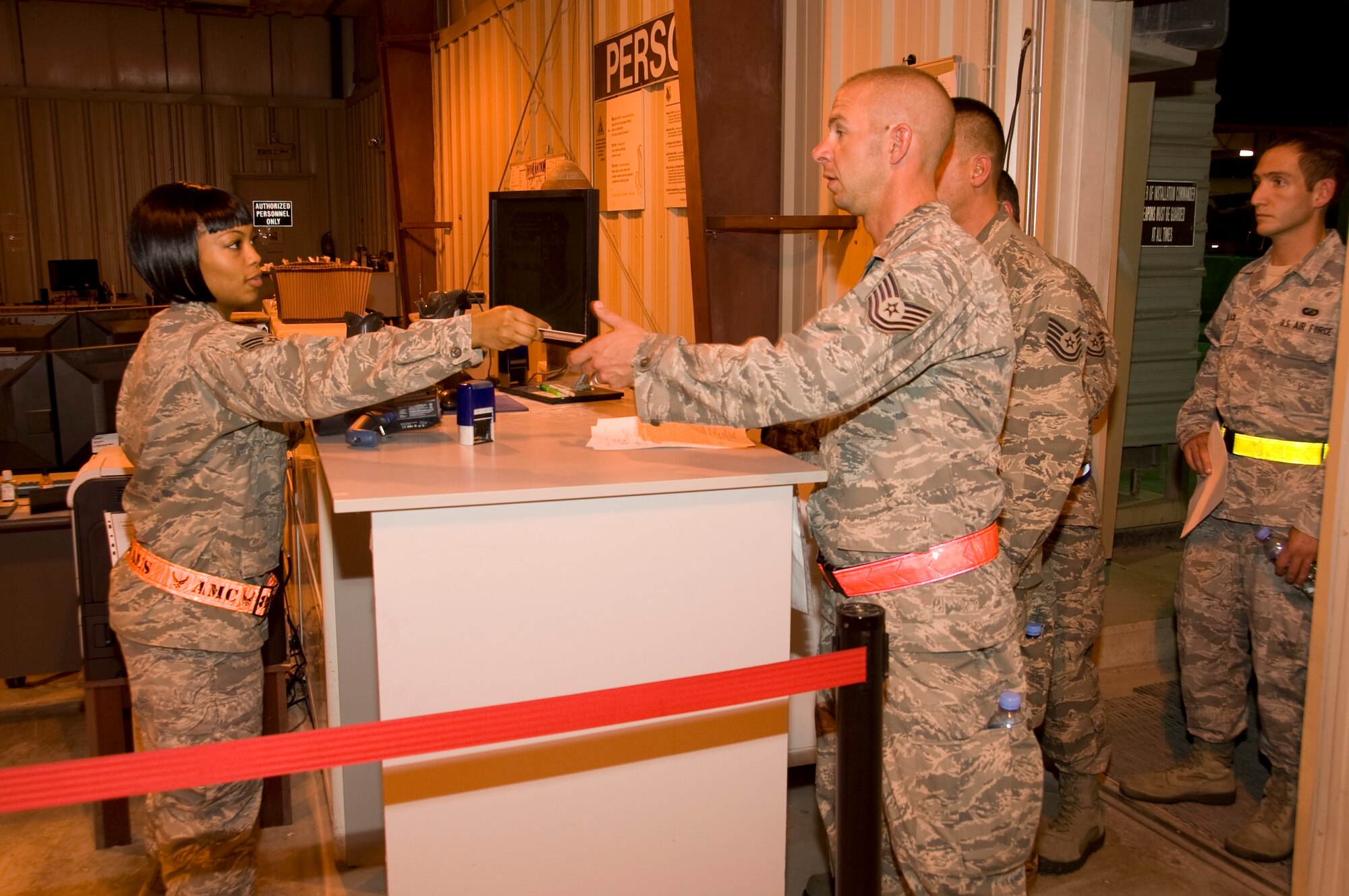 Senior Airman Chenell Simmons, 379th Expeditionary Force Support Squadron PERSCO reception control center member, scans identification cards and stamps orders for any new arrival to Southwest Asia. PERSCO accounts for 100 percent of people that come through here, regardless of their length of stay and ensures a smooth transition through immigrations and customs. (U.S. Air Force photo/Senior Airman Bryan Swink)
