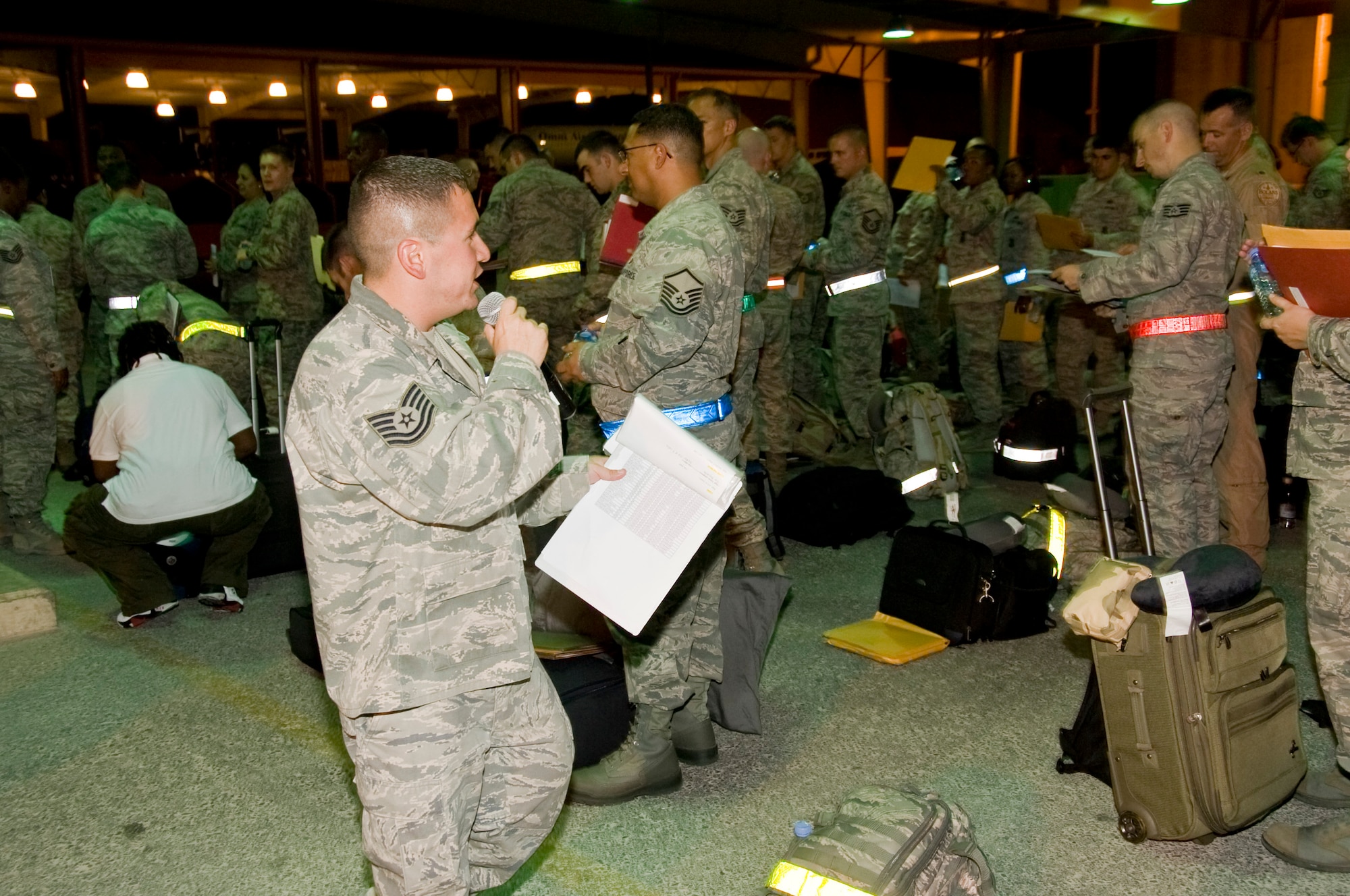 Technical Sgt. Adrian Salas, 379th Expeditionary Force Support Squadron PERSCO reception control center member, informs the arriving service members of the paper work they will need to process through immigrations and customs in Southwest Asia July 5, 2012. The RCC team ensures all passengers are taken care of and remain as comfortable as possible during the time following their long flight. (U.S. Air Force photo/Senior Airman Bryan Swink)