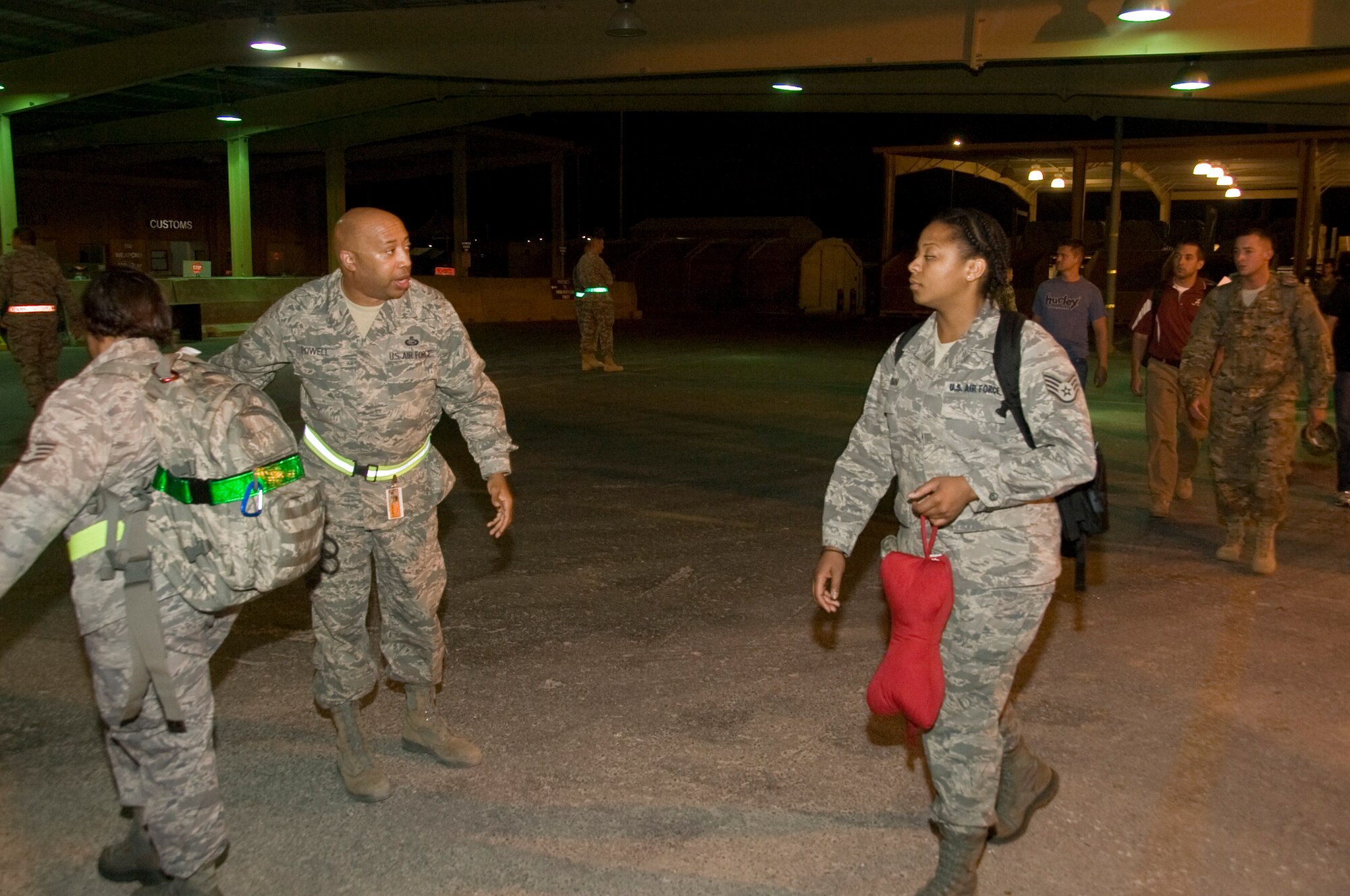 Master Sgt. Arthur Powell, 379th Expeditionary Force Support Squadron PERSCO reception control center member, directs the flow of traffic of new arrivals to the base. The service members arrived in the early hours of July 5, 2012 and the PERSCO team is the first ones to greet them. PERSCO is broken into three divisions; customer service, deliberate crisis action planning execution segments and the reception control center. (U.S. Air Force photo/Senior Airman Bryan Swink)