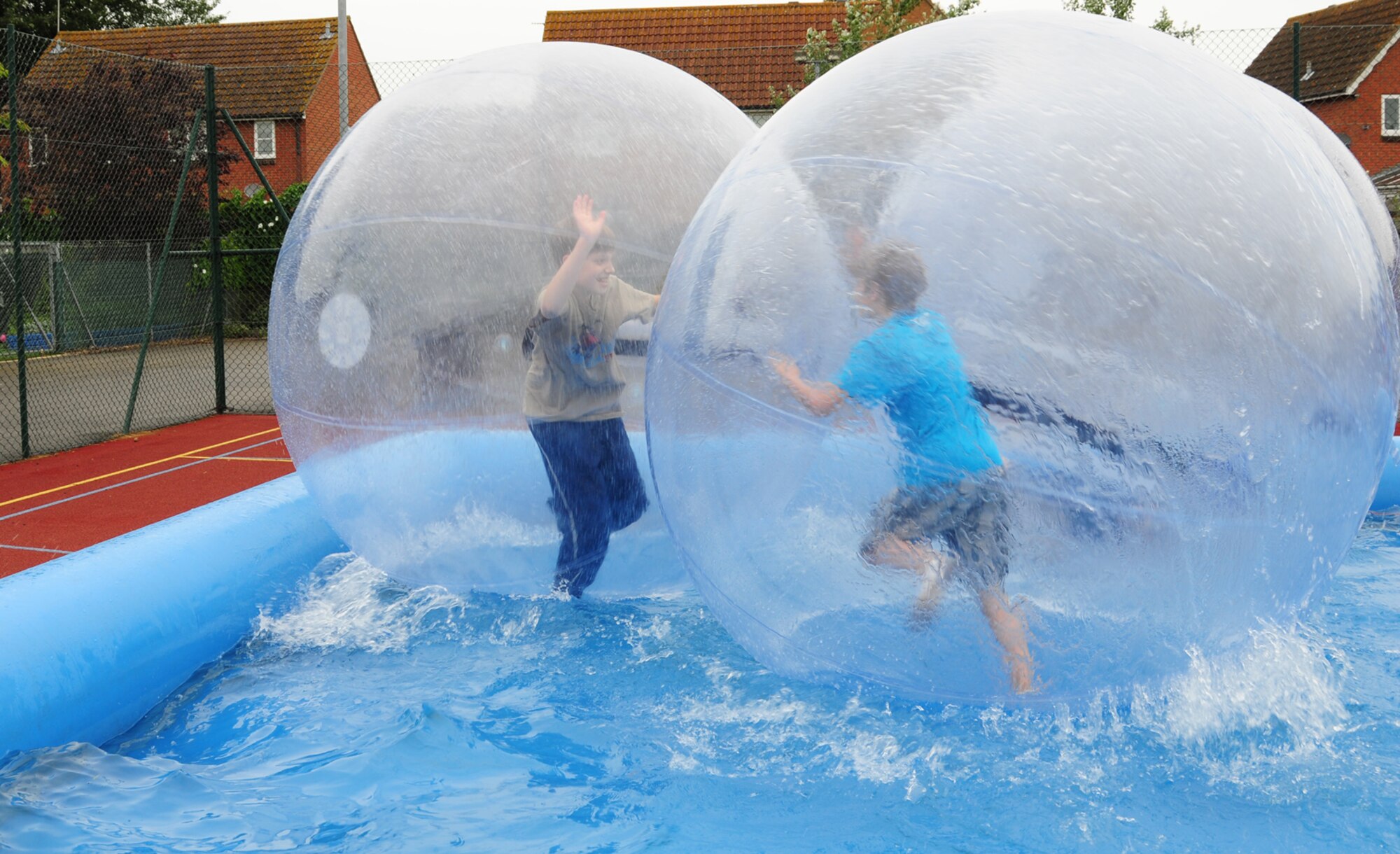 RAF MILDENHALL, England – Jakob Hollinger, 11, and Aidan Driver, 12, both Team Mildenhall children, battle it out during water zorbing held at the RAF Mildenhall Youth Center July 2, 2012. Zorbing  was just one of many activities and camps which are available at the youth center over the summer. For more information on other activities for children, call the youth center at DSN 238-2831. (U.S. Air Force photo/Karen Abeyasekere)