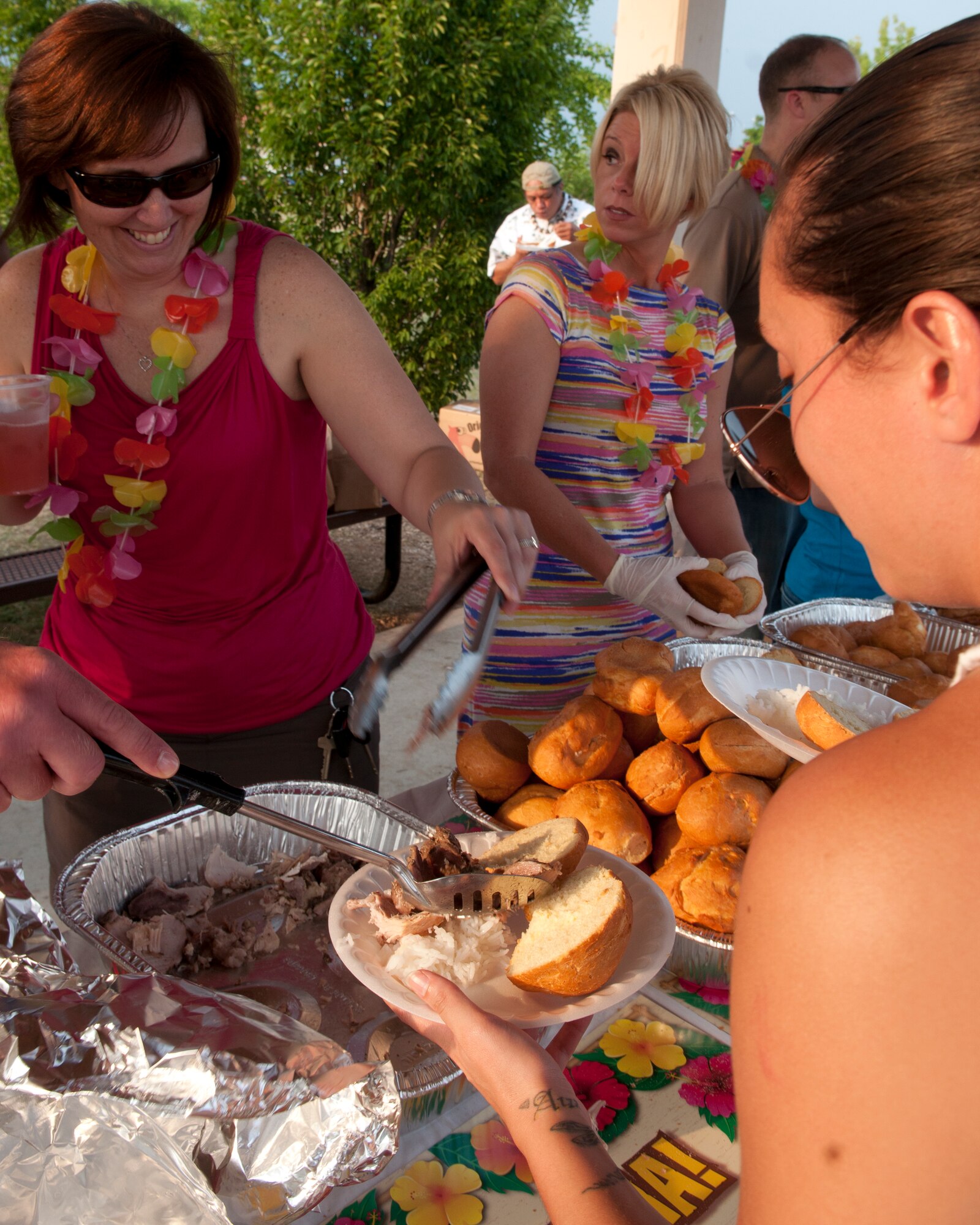 Senior Master Sgt. Stacy Pearson, 31st Munitions Squadron first sergeant, serves food to Senior Airman Uilani Forgione June 29 at Aviano Air Base, Italy. A Luau was sponsored by the Airman and Family Readiness Center and other organizations to improve morale for Airmen in the dorms. (U.S. Air Force photo/Airman 1st Class Briana Jones)