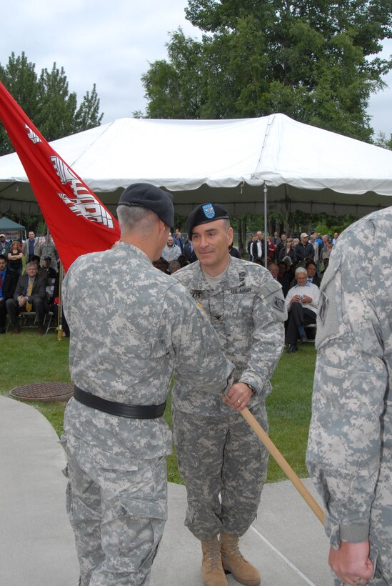 Brig. Gen. Richard L. Stevens, commander of the U.S. Army Corps of Engineers, Pacific Ocean Division, hands the unit guidon to incoming Alaska District Commander, Col. Christopher D. Lestochi during a change of command ceremony today on Joint Base Elmendorf-Richardson. 