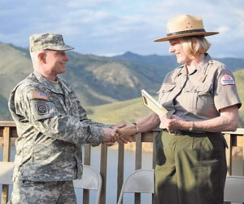 VISALIA, CALIF., -- Army Corps of Engineers Maj. Gen. Bo Temple hands Valerie McKay, a park ranger with the corps, a book on Thursday at Lake Kaweah. Temple flew from Washington, D.C., in part, to meet McKay, whose late grandfather fought in World War I for the British and participated in the 1914 Christmas Day Truce. 