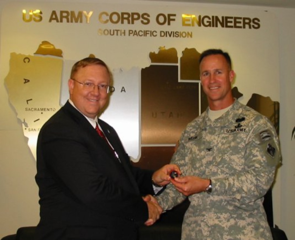 Terry Edwards, Director of the Air Force Center for Engineering and the Environment (AFCEE), receives the U.S. Army Corps of Engineers South Pacific Coin from Division Commander Colonel Mike Wehr.