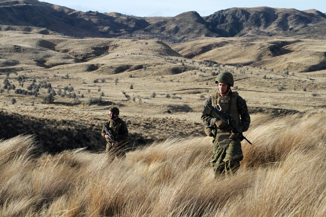 New Zealand Army Gunner Bronson K. Ebbett, a command post operator with 163 Battery, 16th Field Regiment, and U.S. Marine Lance Cpl. Joseph S. Meraz, an artilleryman with Alpha Battery, 1st Battalion, 11th Marine Regiment, scout out a new gun position during Exercise Brimstone here, June 23. Ebbett, a 19-year-old native of Christchurch, New Zealand, and Meraz, a 22-year-old native of Tucson, Ariz., served on the battery's reconnaissance team and arrived on location to prepare the ground for the gun line. Exercise Brimstone is a part of Exercise Galvanic Kiwi, a U.S. Marine Corps and New Zealand Army training exchange designed to enhance interoperability and foster military-to-military relations between the U.S. and New Zealand.