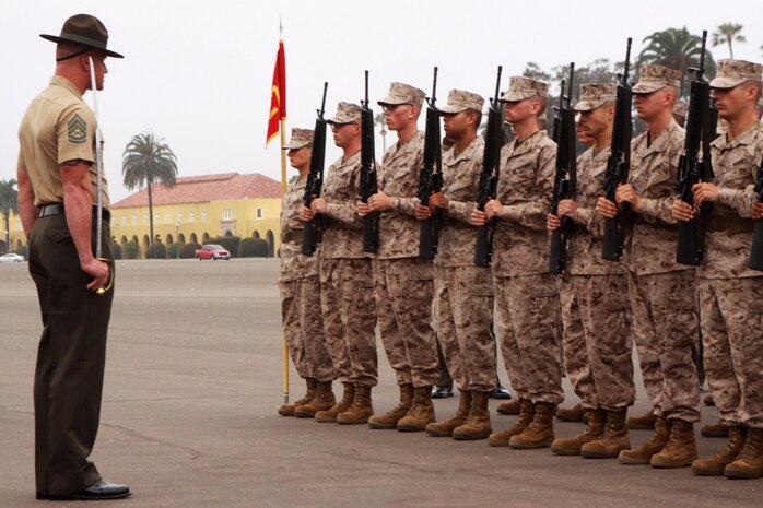 Recruits with Platoon 3273, Company M, 3rd Recruit Training Battalion wait for Gunnery Sgt. Jeffrey E. Liske, senior drill instructor, to sound the command port arms during a final drill competition June 18. Platoons with Co. M all participated in final drill which was graded by drill instructors, also known as drill masters. The drill masters determine the score of how well the platoon completes a series of movements.