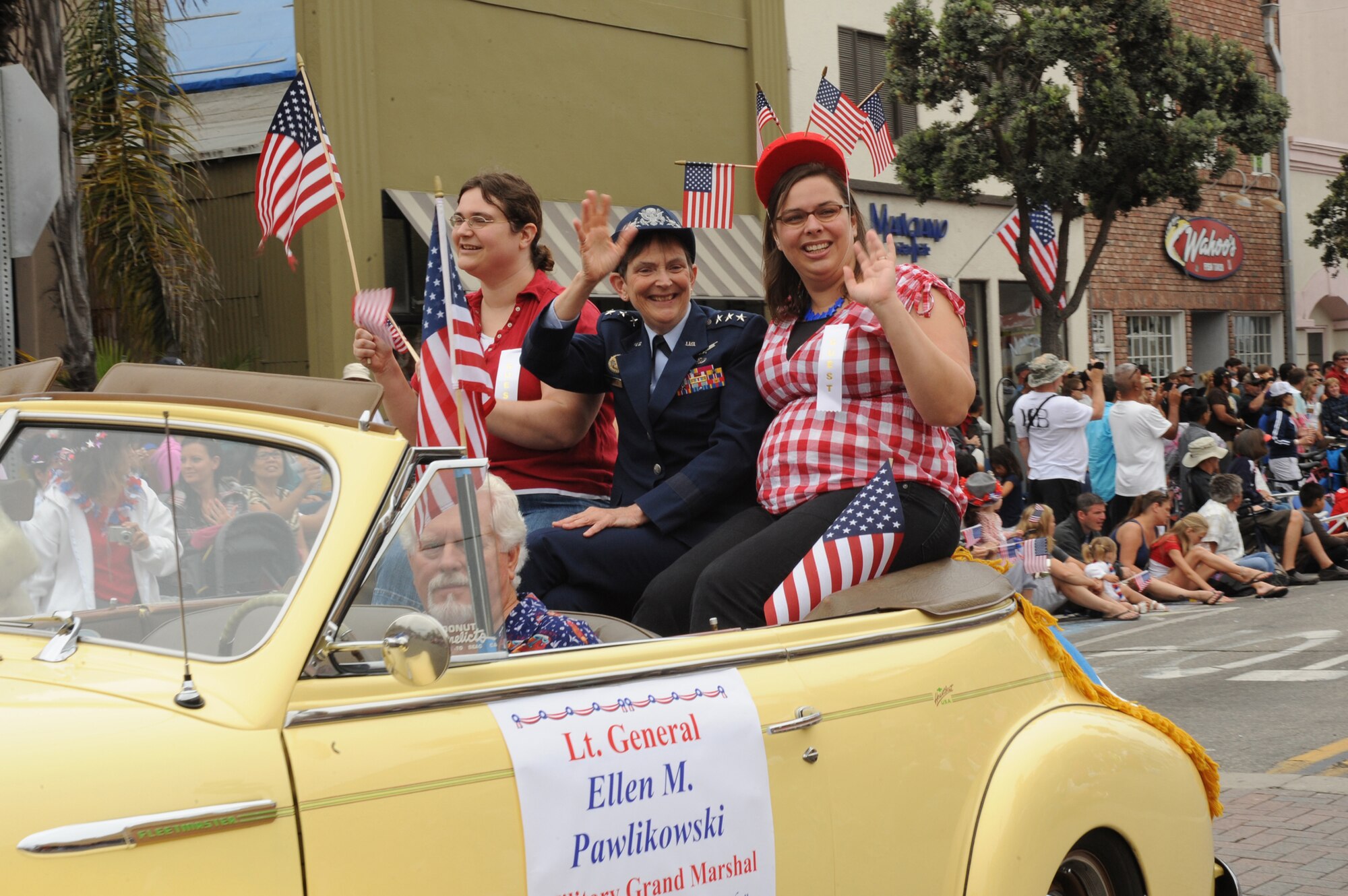 Lieutenant Gen. Ellen Pawlikowski, SMC commander, and her daughters Jennifer and Laura wave to the crowds during the Huntington Beach 4th of July parade. The general was the military grand marshal.  This year was the city's 108th annual parade. (Photo by Sarah Corrice) 