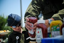 Joe Englehardt, 5, prepares to enjoy a hamburger with his dad, Maj. Mike Englehardt, Air Force Special Operations Command safety office June 29, 2012, at Hurlburt Field, Fla. AFSOC hosted Bring Your Child to Work Day. (U.S. Air Force photo by Staff Sgt. David Salanitri) 
