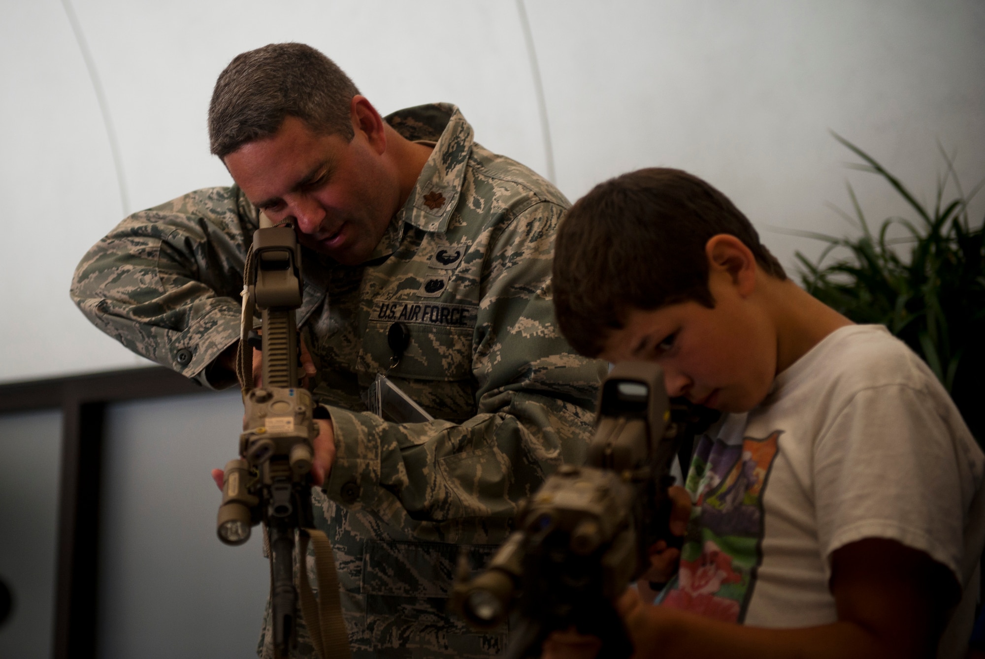 Maj. Bradley Ball, Air Force Special Operations Command Staff Judge Advocate, and son Garrette, 11, look through the optics of weapons commonly used by AFSOC Airmen, June 29, 2012, during AFSOC's Bring Your Child to Work Day at Hurlburt Field, Fla. (U.S. Air Force photo by Staff Sgt. David Salanitri) 