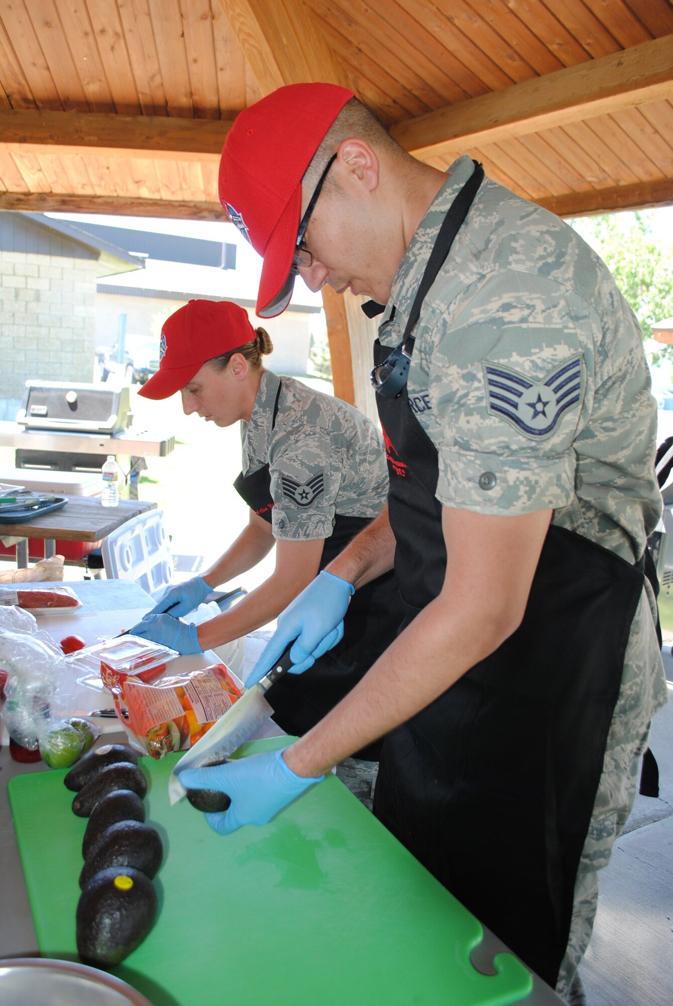 Staff Sgt. Jeanne Smith, 819th RED HORSE Squadron services member, left, slices red peppers as Staff Sgt. Ernesto Roman-Cruz, 819th RHS services member, cuts an avocado to prepare guacamole to add to their pork tenderloin dish during the 2nd-Quarter Warrior Chef Competition at Sun Plaza Park on June 28. (U.S. Air Force photo/Airman 1st Class Katrina Heikkinen)
