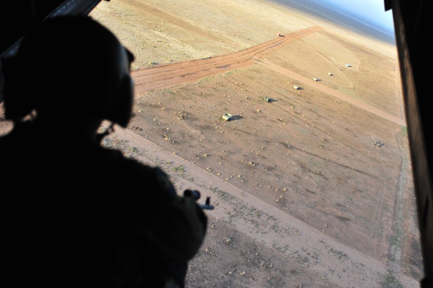 U.S. Air Force Staff Sgt. Casey Spang, 20th Special Operations Squadron flight engineer, surveys the area while flying over Melrose Air Force Range, N.M., July 5, 2012. The 20 SOS conducted a routine training flight over Melrose. (U.S. Air Force photo by Airman 1st Class Alexxis Pons Abascal) 

