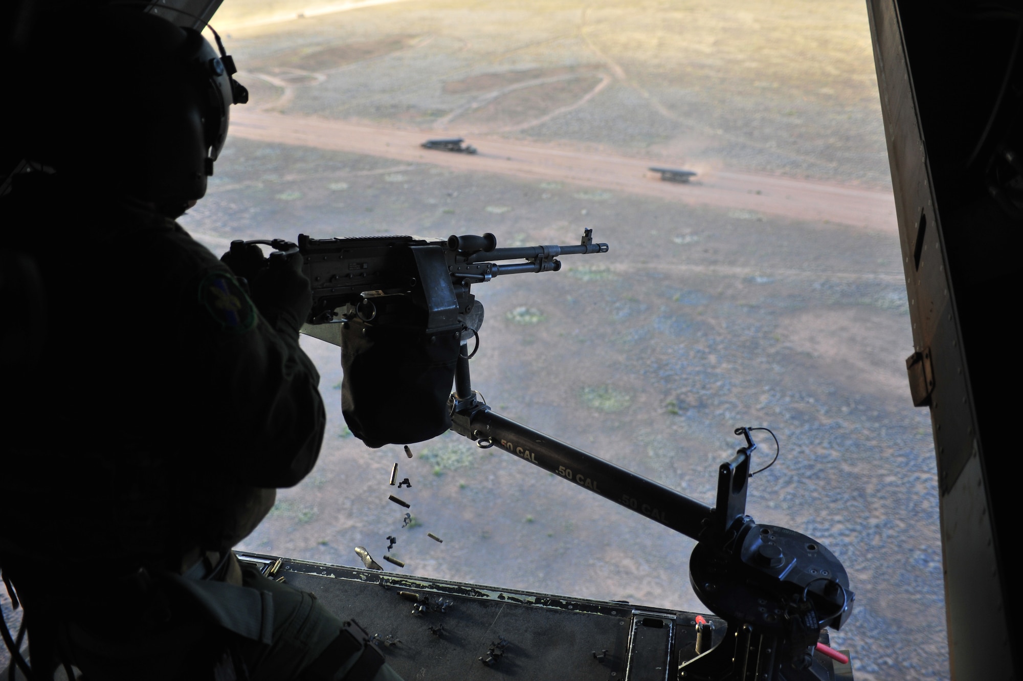 U.S. Air Force Staff Sgt. Casey Spang, 20th Special Operations Squadron flight engineer, fires a 50 caliber weapon out the back of a CV-22 Osprey while flying over Melrose Air Force Range, N.M., July 5, 2012. The 20 SOS conducted a routine training flight over Melrose. (U.S. Air Force photo by Airman 1st Class Alexxis Pons Abascal) 

