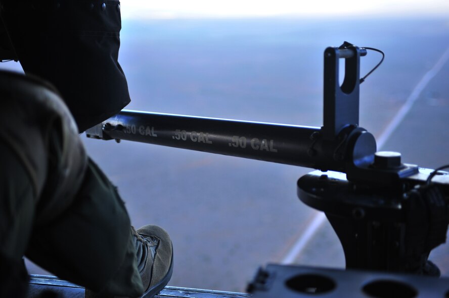 U.S. Air Force Staff Sgt. Casey Spang, 20th Special Operations Squadron flight engineer, sits harnessed near a 50 caliber weapon in the back of a CV-22 Osprey while flying over Melrose Air Force Range, N.M., July 5, 2012. The CV-22 Osprey is a tilt-rotor aircraft that combines the vertical takeoff, hover and vertical landing qualities of a helicopter with the long-range, fuel efficiency and speed characteristics of a turbo-prop aircraft. (U.S. Air Force photo by Airman 1st Class Alexxis Pons Abascal) 