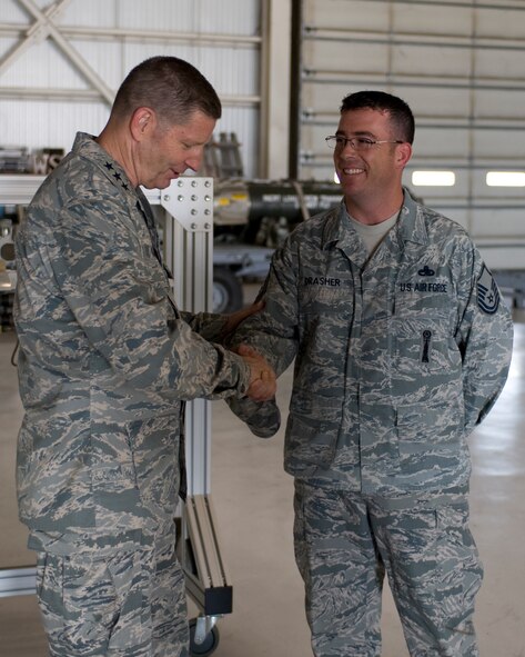U.S. Air Force Lt. Gen. Robin Rand, 12th Air Force commander, left, presents Master Sgt. Troy Drasher, 7th Munitions Squadron weapons standardization crew member, with a commander’s coin during his tour of the load crew training facility July 2, 2012, at Dyess Air Force Base, Texas. During his visit, Rand 