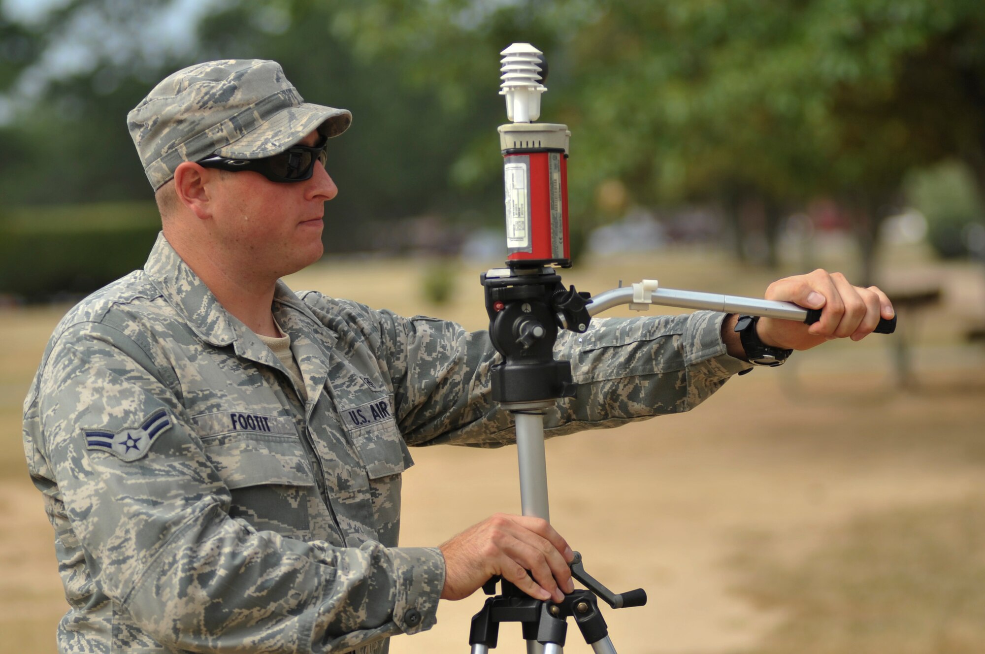 Airman 1st Class Mathew Footit, a 19th Aerospace Medical Squadron bio and enviromental technician, sets up a wet bulb globe temperature monitor July 3, 2012, at Little Rock Air Force Base, Ark. The monitor caluculates temperatures, which are used to assign heat stress categories. (U.S. Air Force photo by Airman 1st Class  Rusty Frank)