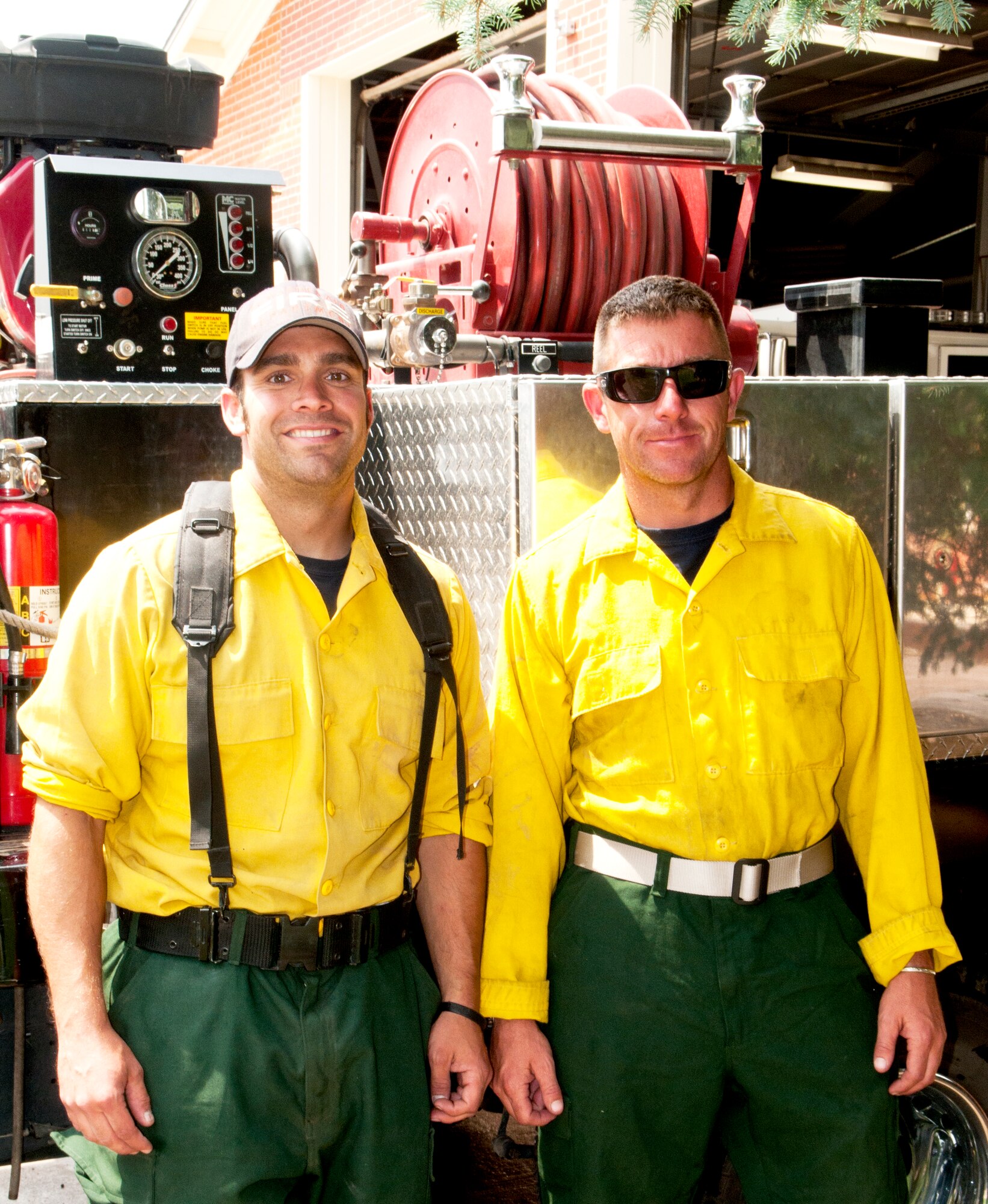 Heath Bichel and Jesse Johnson, 90th Civil Engineer Squadron firefighters,  pose outside of Building 324 in front of Brush 15, the fire truck they drove to Colorado Springs, Colo., to fight wildfires that threatened the U.S. Air Force Academy from June 27 to June 29. (U.S. Air Force photo by Airman 1st Class Jason Wiese)