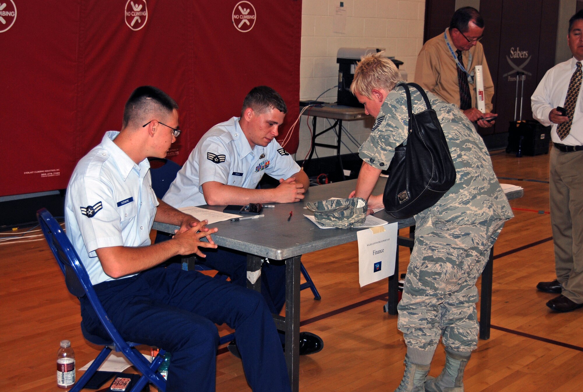 Tech. Sgt. Tracey Barry (right), 302nd Airlift Wing recruiter, seeks assistance from representatives of the finance office during the Waldo Canyon Fire Support Fair July 2 in the R.P. Lee Youth Center. Members of the 21st Force Support Squadron organized the event  to assist military members from Peterson and Schriever Air Force Bases and Department of Defense civilians who were displaced by the fire. (U.S. Air Force photo/Lea Johnson)