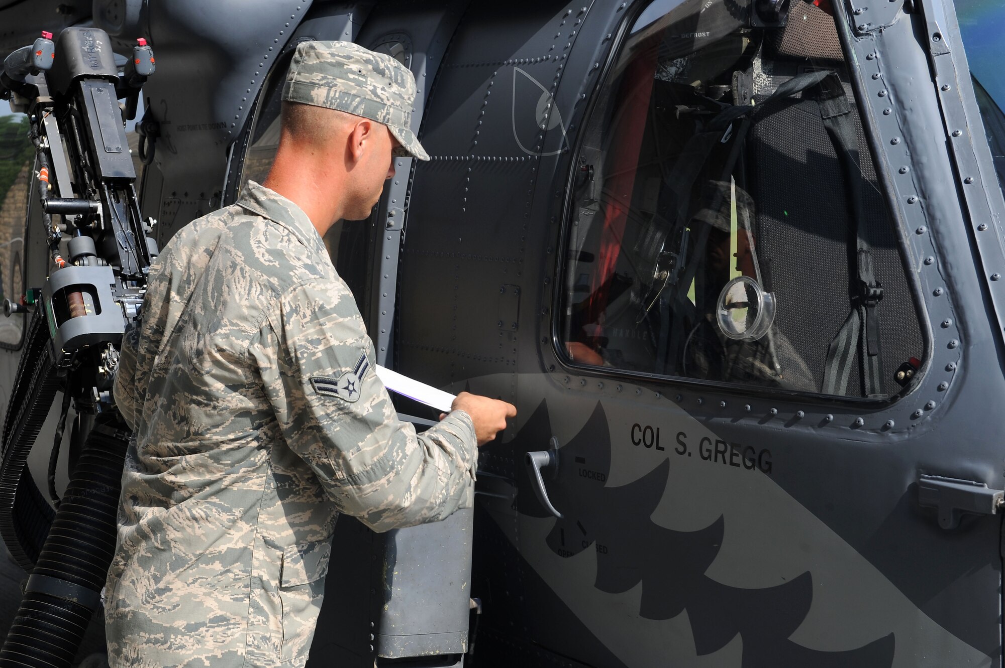 U.S. Air Force Airman 1st Class Joshua Jaynes, 723d Aircraft Maintenance Squadron crew chief, unveils the nameplate of Col. Steven Gregg, 347th Rescue Group commander, on an HH-60G Pave Hawk, July 5, 2012.  The unveiling served as another way for the 347th RQG to officially greet and welcome Col. Gregg as the new commander. (U.S. Air Force photo by Staff Sgt. Ciara Wymbs/Released)