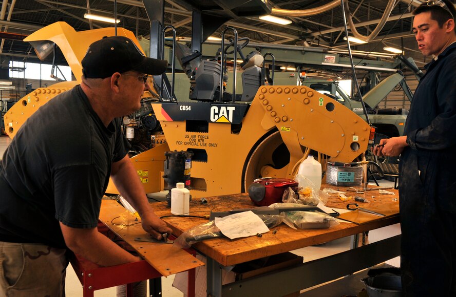 David Collinsworth and U.S. Air Force Airman 1st Class Tyler Werle, 27th Special Operations Logistics Readiness Squadron heavy equipment technicians, repair a Caterpillar construction roller at Cannon Air Force Base, N.M., July 3, 2012. Collinsworth and Werle are part of the heavy equipment shop that assists the other vehicle repair shops on base with maintaining all government-owned vehicles. (U.S. Air Force photo by Airman 1st Class Ericka Engblom)

