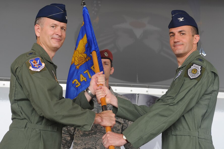 U.S. Air Force Col. Billy Thompson, left, 23d Wing commander, passes the guidon to Col. Steven Gregg, incoming 347th Rescue Group commander, at Moody Air Force Base, Ga., July 5, 2012. The passing of the guidon is symbolic of a new commander taking command of a squadron, group or wing. (U.S. Air Force photo by Staff Sgt. Ciara Wymbs/Released) 