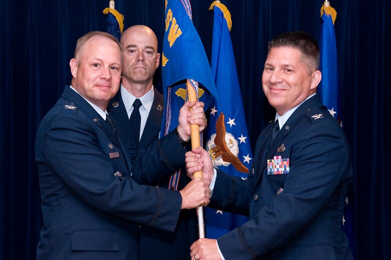 PETERSON AIR FORCE BASE, Colo. -- Col. Charles Arnold (right), 21st Mission Support Group commander, accepts the 21st MSG guidon from Col. Chris Crawford, 21st Space Wing commander, June 27, 2012, in The Club. Arnold arrived here from The Pentagon, and replaces Col. Kimerlee Conner, who recently retired. (U.S. Air Force photo/Craig Denton)