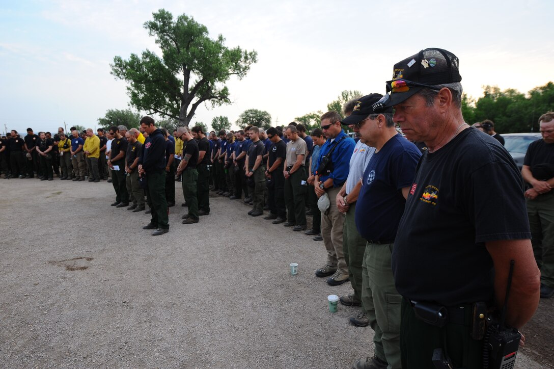 Firefighters pause to reflect on the sacrifices of fellow firefighters and Airmen who gave their lives battling the spreading White Draw Wildfire in southwest South Dakota, during a memorial service in Edgemont, S.D., July 5, 2012. The C-130 from the 145th Airlift Wing, North Carolina Air National Guard was equipped with a Mobile Aerial Fire Fighting System and was aiding local firefighters when it crashed July 1, 2012, killing four crew members and injuring two others. (U.S. Air Force photo by Airman 1st Class Zachary Hada/Released) 