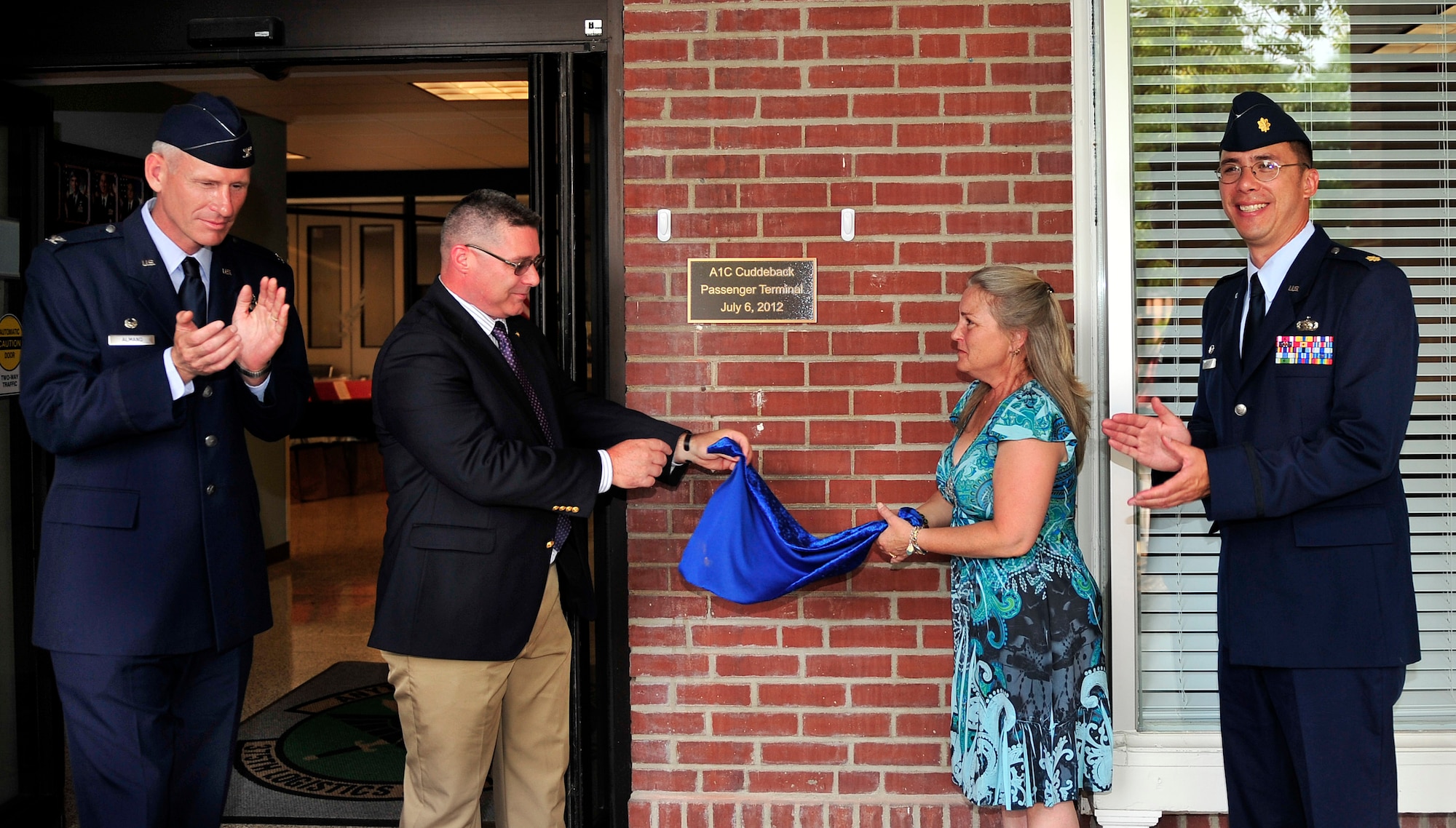 Robert Cuddeback, father, and Celia Loyet, mother of Airman 1st Class Zachary Ryan Cuddeback unveil a bronze plaque dedicating the Scott Air Force Base, Ill. passenger terminal to their son’s service July 6, 2012. The plaque will remain at the entrance of the terminal. Zachary was a vehicle operator assigned to Ramstein Air Base, Germany when he was mortally wounded March 2, 2011 by a terrorist while transporting Air Force Security Force members to the airport.  He was born on Scott Air Force Base, July 6 1989. Today he would be 23-years-old. He was buried in O’Fallon, Ill. (U.S. Air Force photo/ Staff Sgt. Stephenie Wade)