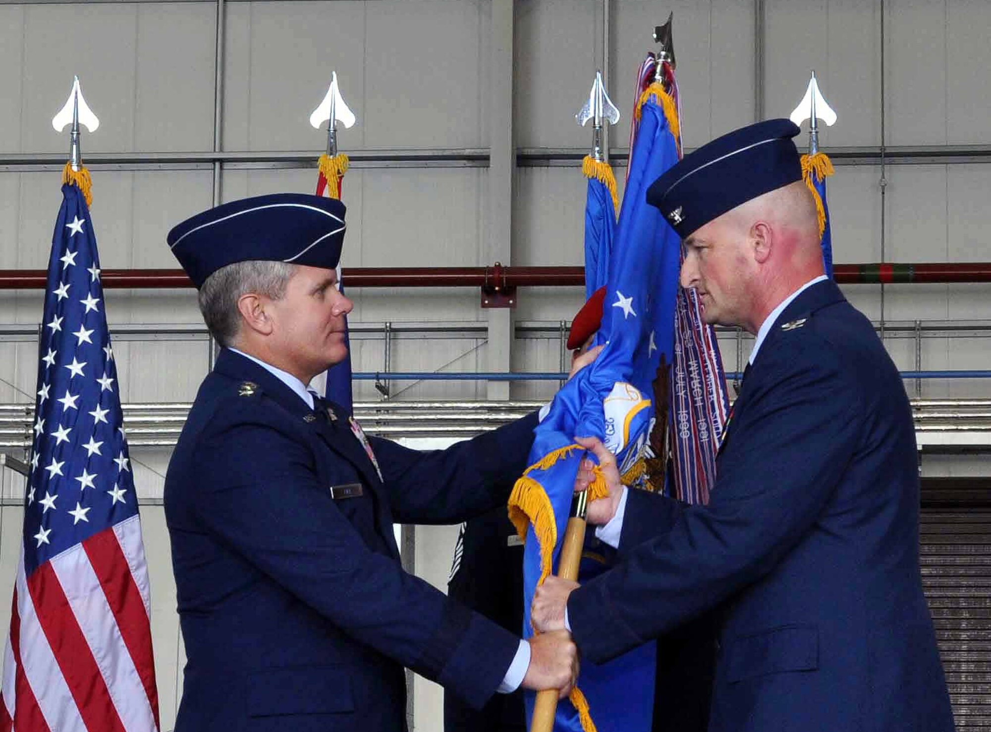 Lt. Gen. Eric E. Fiel, Air Force Special Operations Command commander, presents the 352nd Special Operations Group guidon, and in turn leadership of the unit, to Col. Christopher Ireland during a change of command ceremony at RAF Mildenhall, England, in Hangar 814 July 6, 2012. Ireland is a senior pilot with more than 3,000 flying hours in multiple airframes, including the MC-130 E/H Combat Talon. (U.S. Air Force photo/Staff Sgt. Thomas Trower)