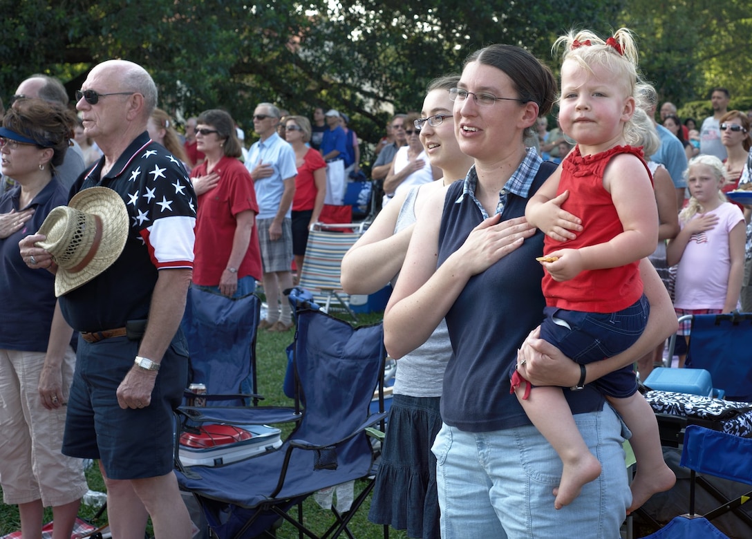 Audience members, including Elaine Warner, 2, hold their hands over their hearts while the U.S. Air Force Heritage of America Concert Band plays the National Anthem at Williamsburg, Va., July 4, 2012. In addition to entertaining and inspiring onlookers, the band served as a tool to allow for interaction between the Air Force and the public. (U.S. Air Force photo by Tech. Sgt. Barry Loo/Released)