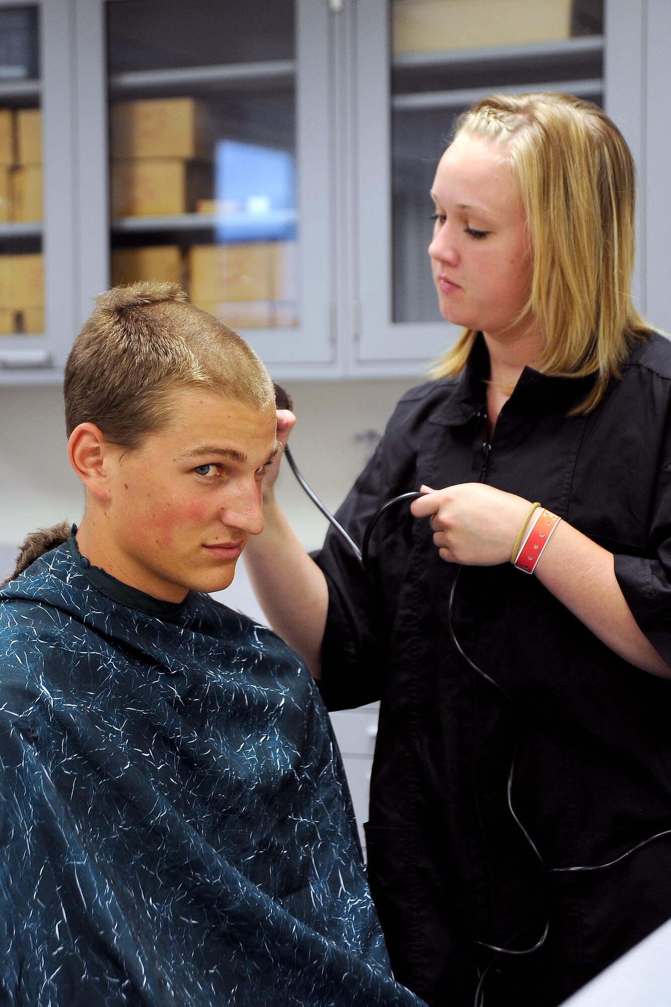 An appointee receives a haircut during inprocessing for the Class of 2016 on June 28. Approximately 1,050 basic cadets joined the Long Blue Line even as the Waldo Canyon fire burned to the south. (U.S. Air Force Photo/Elizabeth Andrews)