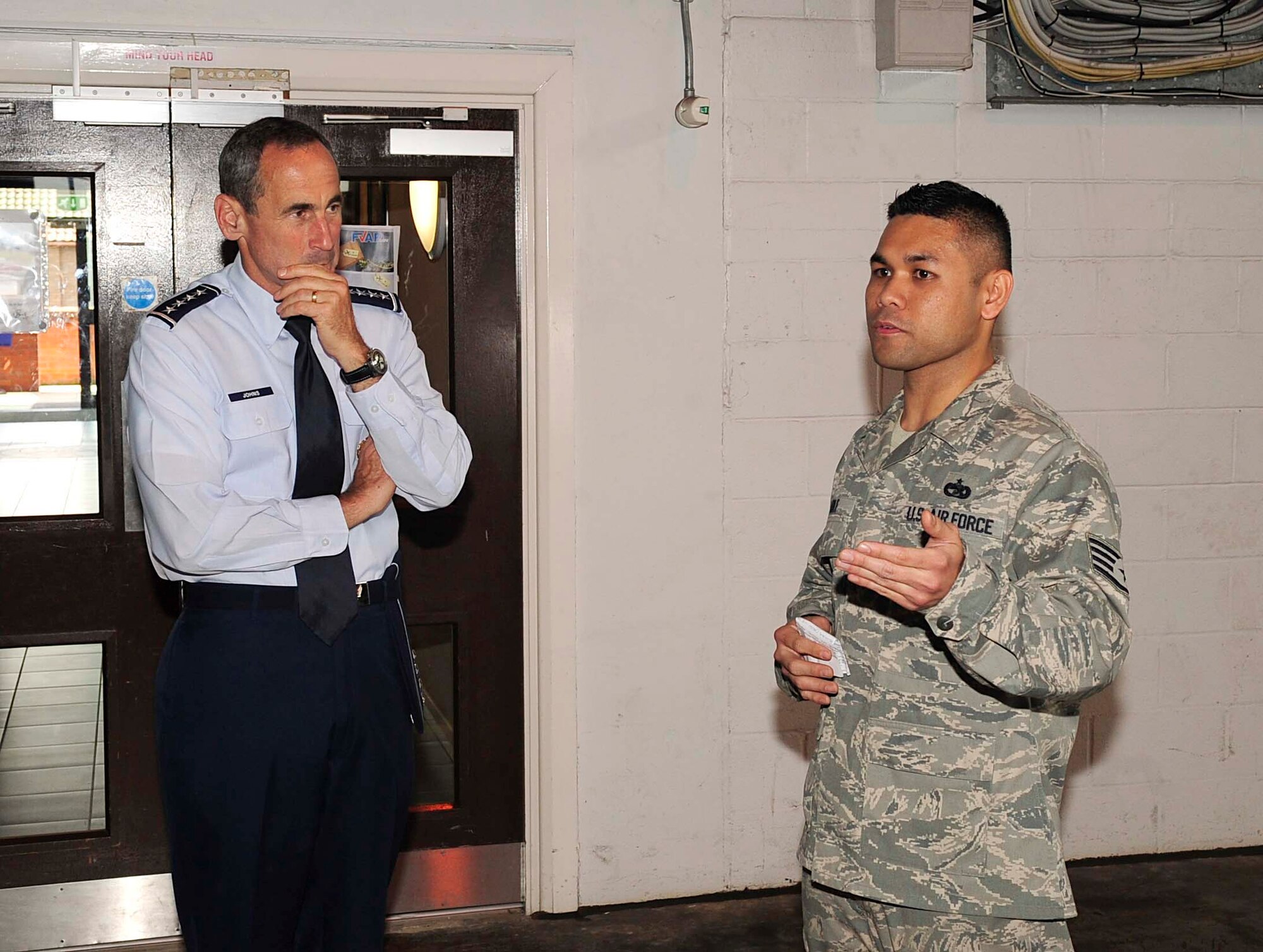 RAF MILDENHALL, England – Staff Sgt. Jaymhar Caoile, 727th Air Mobility Squadron freight services supervisor, briefs Gen. Raymond Johns, Air Mobility Command commander, during a visit to RAF Mildenhall,  July 5, 2012. Caoile explained the day-to-day operations of the 727th AMS freight services. (U.S. Air Force photo/Senior Airman Ethan Morgan)