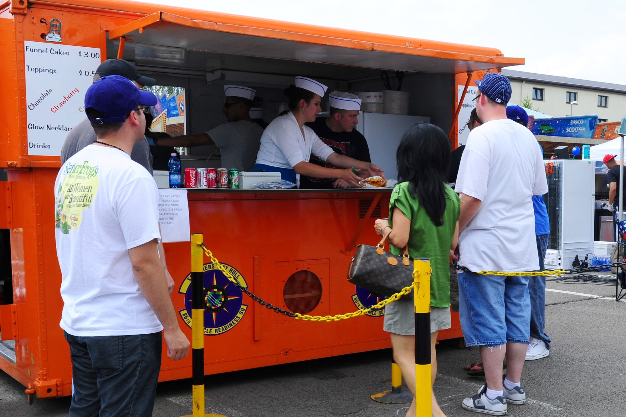 Members of the 86th Vehicle Readiness Squadron serve funnel cake, coke and water to members of Team Ramstein at the 86th Force Support Squadron’s annual Kaiserslautern Military Community Independence Day celebration, “The Rockin’ 4th,” at the Enlisted Club on Ramstein Air Base, Germany, July 4, 2012. The Festivities included live music, children’s activities, carnival rides, food specialties, a Ferris wheel, bumper cars and a fireworks display at dusk. (U.S. Air Force photo/Airman 1st Class Holly Cook)   