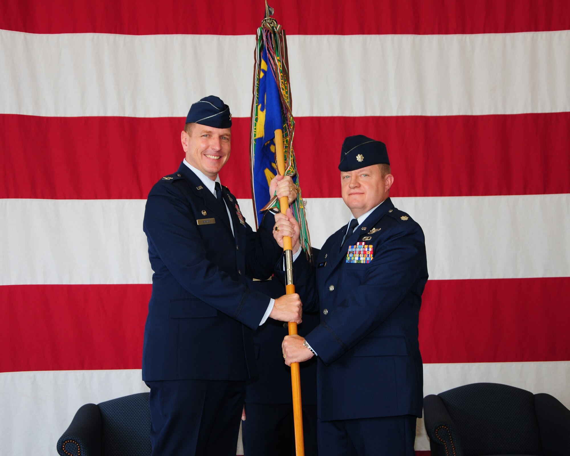 Col. Steve Stater, 14th Operations Group Commander, passes the 49th Fighter Training Squadron guidon to Lt. Col. Neil Oakden, 49th FTS Commander during a change of command ceremony on June 29 at the Fuels Maintenance Hangar. (U.S. Air Force photo/Melissa Doublin)