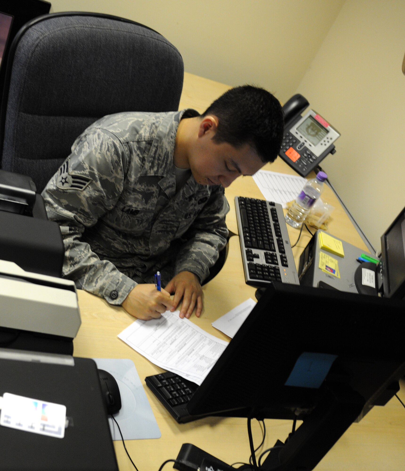 RAF MILDENHALL, England – Senior Airman Parker Lamb, 100th Security Forces Squadron installation access control system administrator, fills out IACS paperwork July 6, 2012 at Bldg. 438. The IACS office is open Monday, Tuesday, Wednesday and Friday from 8:30 a.m. to 3:30 p.m., and Thursday 8:30 a.m. to 5:30 p.m. for Airmen and their dependents to register their ID. (U.S. Air Force photo/Senior Airman Rachel Waller)