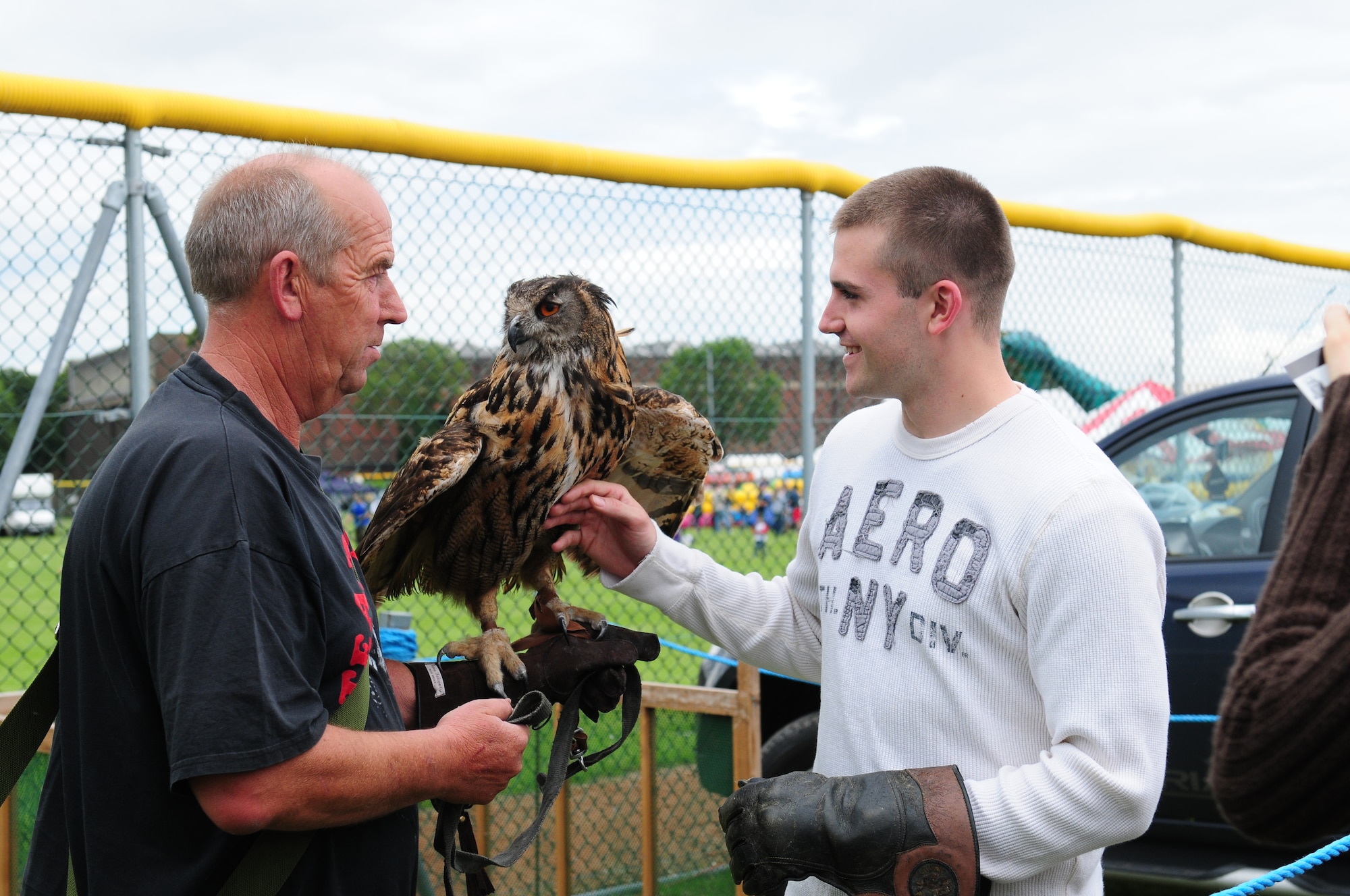 ROYAL AIR FORCE FELTWELL, England - Keith Mutton, Phoenix Bird Control falconer, shows Twinkle, an eagle owl, to Senior Airman David Dansby, 48th Security Forces police services, at the birds of prey demonstration during the Independence Day celebration here July 4, 2012. Approximately 30,000 Airmen, civilians and U.K. residents attended the event. The celebration included carnival games, rides, aerial demonstrations, a birds of prey demonstration and an Idols World Tour performance. (U.S. Air Force by Airman 1st Class Cory D. Payne)
