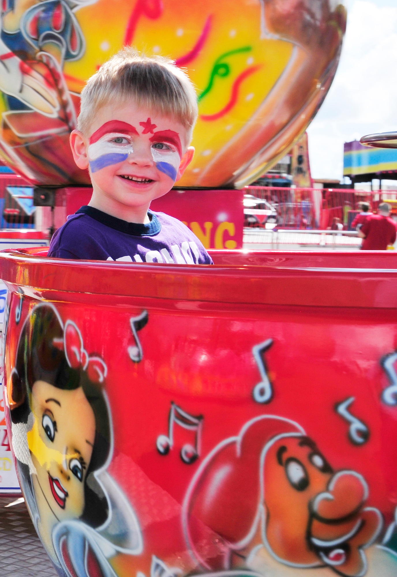 ROYAL AIR FORCE FELTWELL, England – Josiah Chambers, 4, enjoys a tea cup ride during the Independence Day celebration here July 4, 2012. Approximately 30,000 Airmen, civilians and U.K. residents attended the event. The celebration included carnival games, rides, aerial demonstrations, a birds of prey demonstration and an Idols World Tour performance. (U.S. Air Force by Senior Airman Tiffany M. Deuel)
