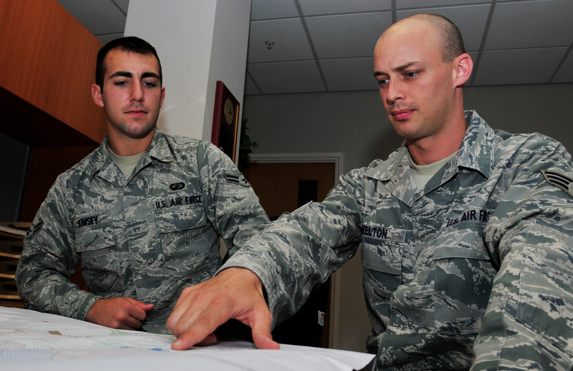ROYAL AIR FORCE LAKENHEATH, England - Senior Airman Benjamin Shelton, 48th Contracting Squadron contract specialist, points out an area on a map to Airman 1st Class Brooks Kimsey, 48th CONS contract administrator, at the Liberty Center July 5, 2012. Shelton was nominated for a Liberty Spotlight for displaying the core value of "Excellence in All We Do." (U.S. Air Force photo by Senior Airman Tiffany M. Deuel)