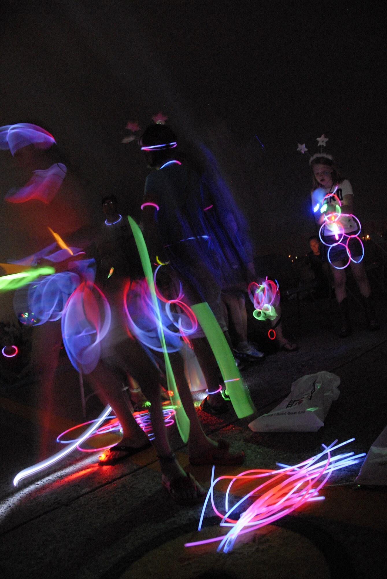 When darkness fell during Liberty Fest at Osan Air Base, Republic of Korea, the 51st Force Support Squadron passed out light sticks for people to wear. Some children -- like Aimee Sutton, daughter of Lt. Col. Richard and Janene Sutton -- looped the lights into wearable art and danced around to the music of LRD before the fireworks display. Liberty Fest was hosted by Osan to commemorate the United States’ Independence Day. (U.S. Air Force photo/Senior Master Sgt. Stuart Camp)