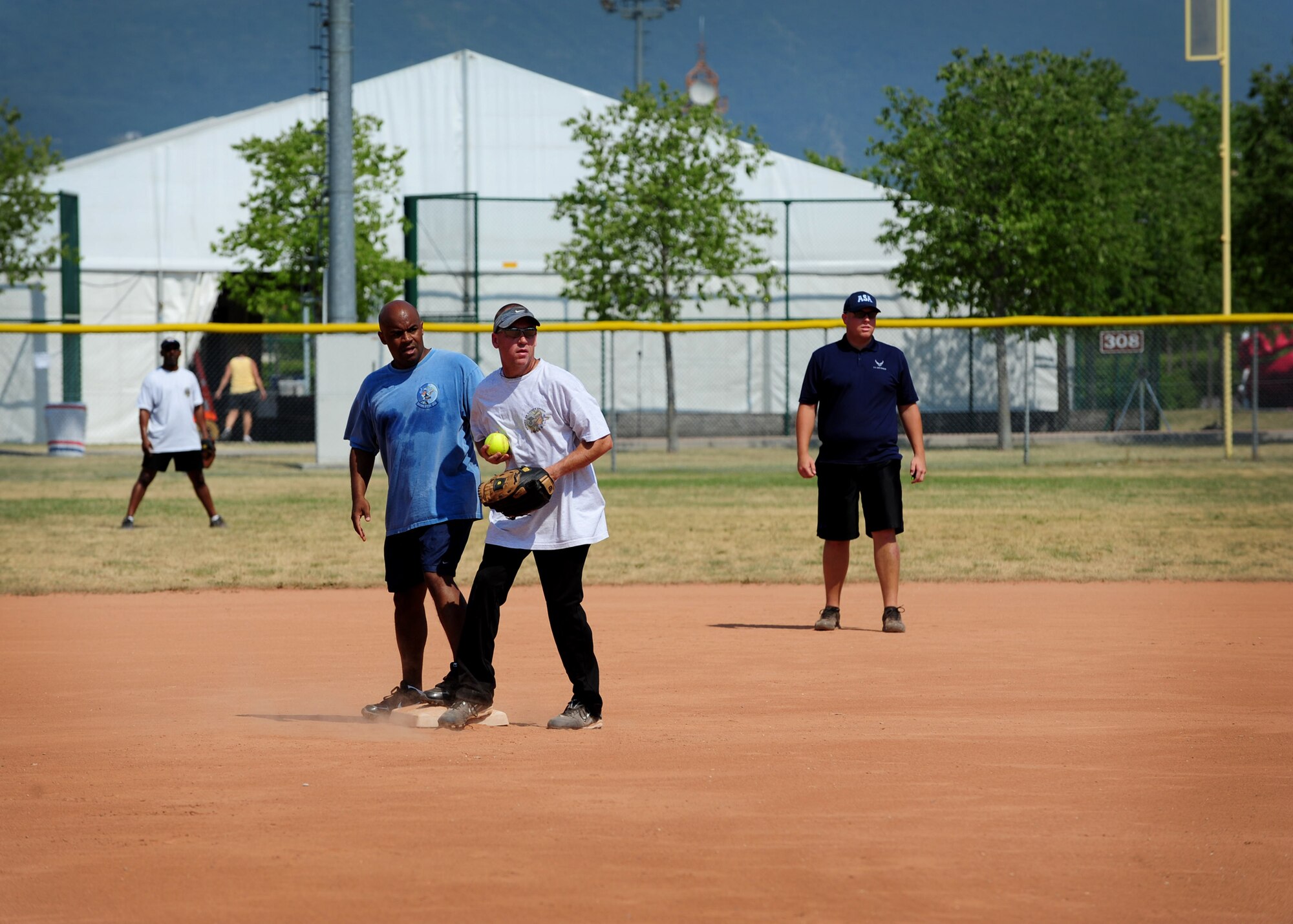 Lt. Col. Kenny Smith, 31st Operations Group commander, stands on third base next to Chief Master Sgt. Todd Folks, 31st Maintenance Group chief enlisted manager, at the Chiefs versus Eagles game July 4 at Aviano Air Base, Italy.  The game is a tradition held during base morale events in which chiefs, colonels, squadron commanders and other honorary participants challenge each other in sporting events. (U.S. Air Force photo by Staff Sgt. Evelyn Chavez)
