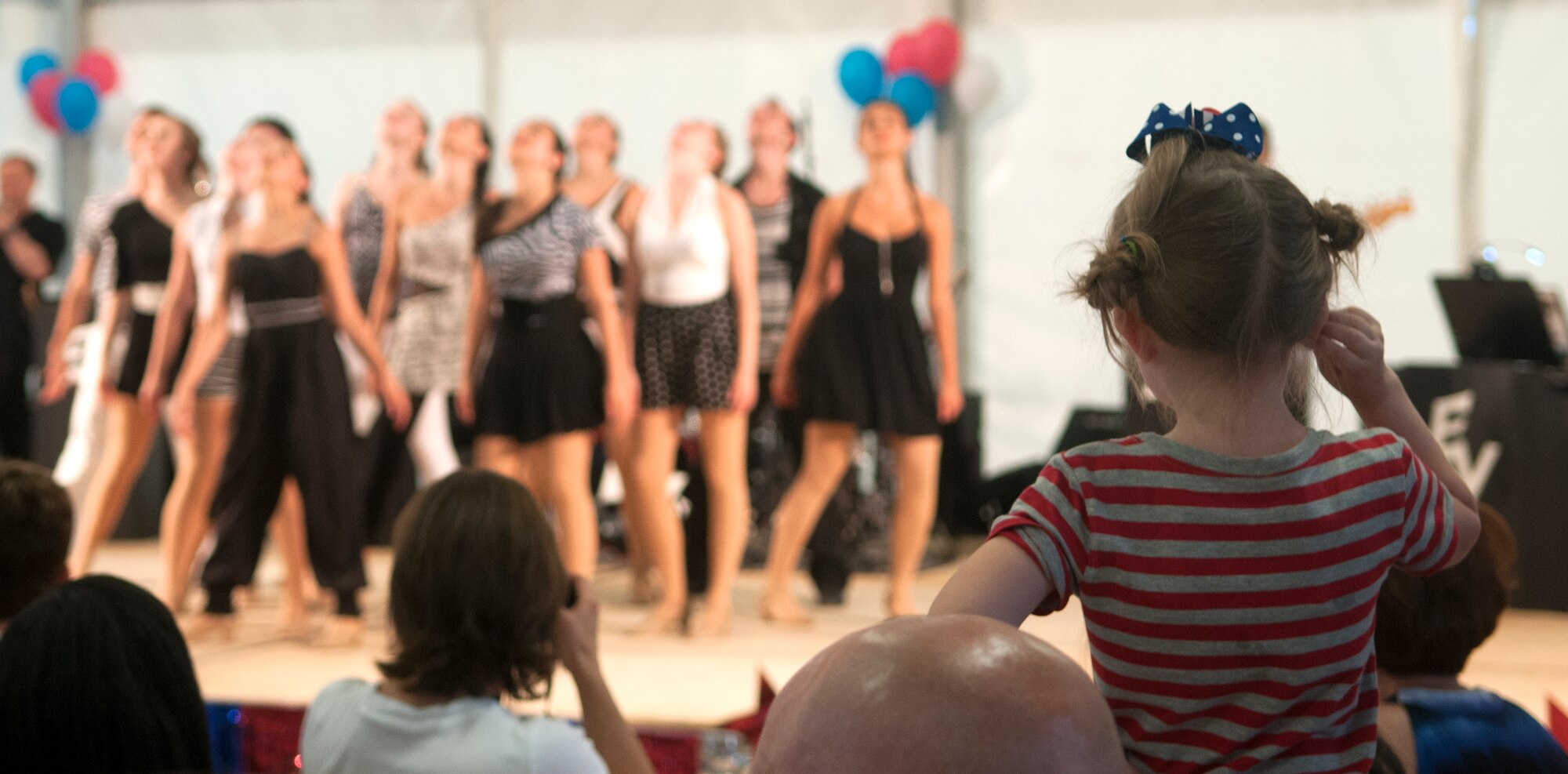 Ruby Neiderhauser, five-year-old daughter of Dan and Chelsie Neiderhauser, watches a performance by Electric Youth during Independence Day celebrations at Aviano Air Base July 4. Thousands visited Aviano for the festivities, during which Italians and Americans came together as a community to celebrate freedom and independence. (U.S. Air Force photo/Senior Airman Katherine Windish)