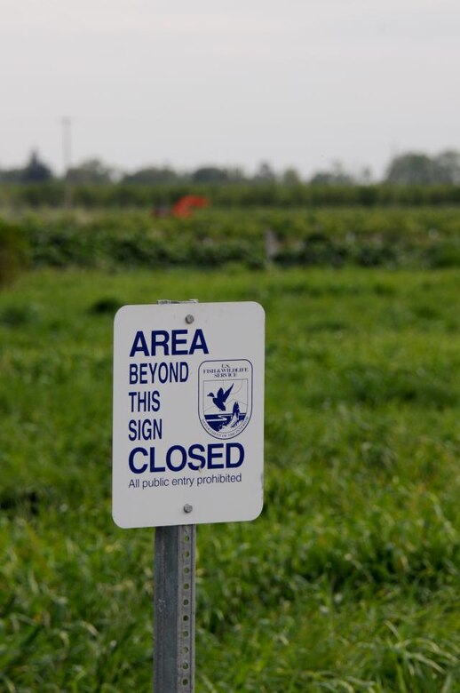 A U.S. Fish &amp; Wildlife Service sign guards public-restricted wetlands between the Sacramento River and private orchards in Hamilton City, Calif. The new setback levees will pass directly between these wetlands and the orchards.
