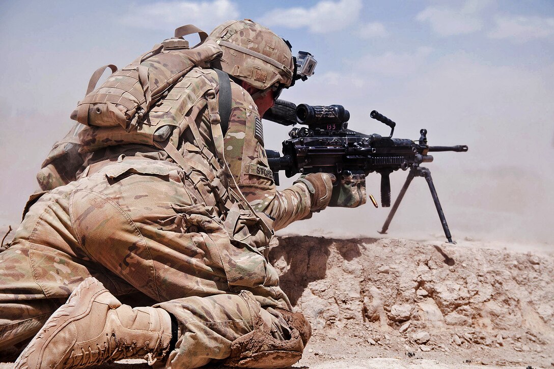 U.S. Army Spc. Shane Storey fires his M249 squad automatic weapon at insurgents during a firefight outside the town of Muqor in Afghanistan's Ghazni province, June 30, 2012. Storey is assigned to the 82nd Airborne Division's 1st Battalion, 504th Parachute Infantry Regiment, 1st Brigade Combat Team.