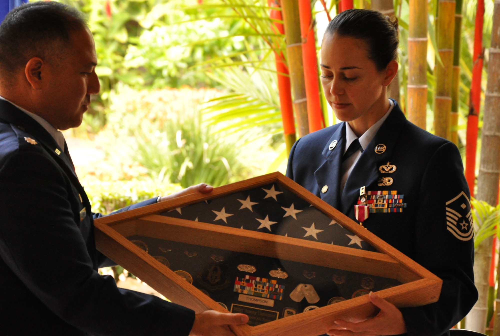 JOINT BASE PEARL HARBOR-HICKAM, Hawaii -- Lt. Col. Randall Honke presents Master Sgt. Tammy Thompson a shadowbox marking her Air Force career at a retirement ceremony held in her honor July 7, 2012, at the Courtyard of Heroes at the Headquarters, Pacific Air Forces building here. Sergeant Thompson retires from the Air Force Reserve after twenty-four years of service. She began her career as a C-5 Galaxy Crew chief in 1988. In February 1995, she cross-trained to become a structural craftsman with the 704th Civil Engineer Squadron here, the present 624th CES. After a few years stint with the 477th CES, Elmendorf, Alaska, she returned to her home with the 624th CES to serve as a First Sergeant. She supported Operation Iraqi Freedom and was chosen as PACAF’s Outstanding First Sergeant of the Year in the Reserve category. (Air Force photo by Master Sgt. Daniel Nathaniel)