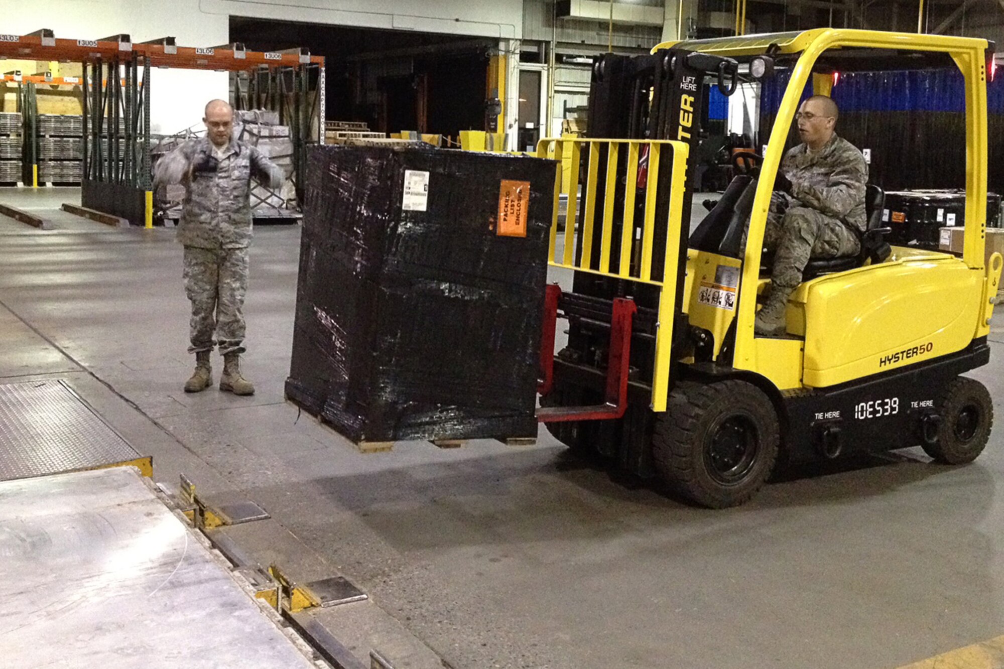 GRISSOM AIR RESERVE BASE, Ind. -- Senior Airman Curtis Tillery, 49th Aerial Port apprentice, loads cargo during a pallet buildup as Staff Sgt. David Lapradd, 49th APF apprentice, guides Tillery's forklift to the correct spot during a recent annual tour training trip to Joint Base Elmendorf-Richardson, Alaska. (U.S. Air Force photo/Tech. Sgt. Bradley Frank) 