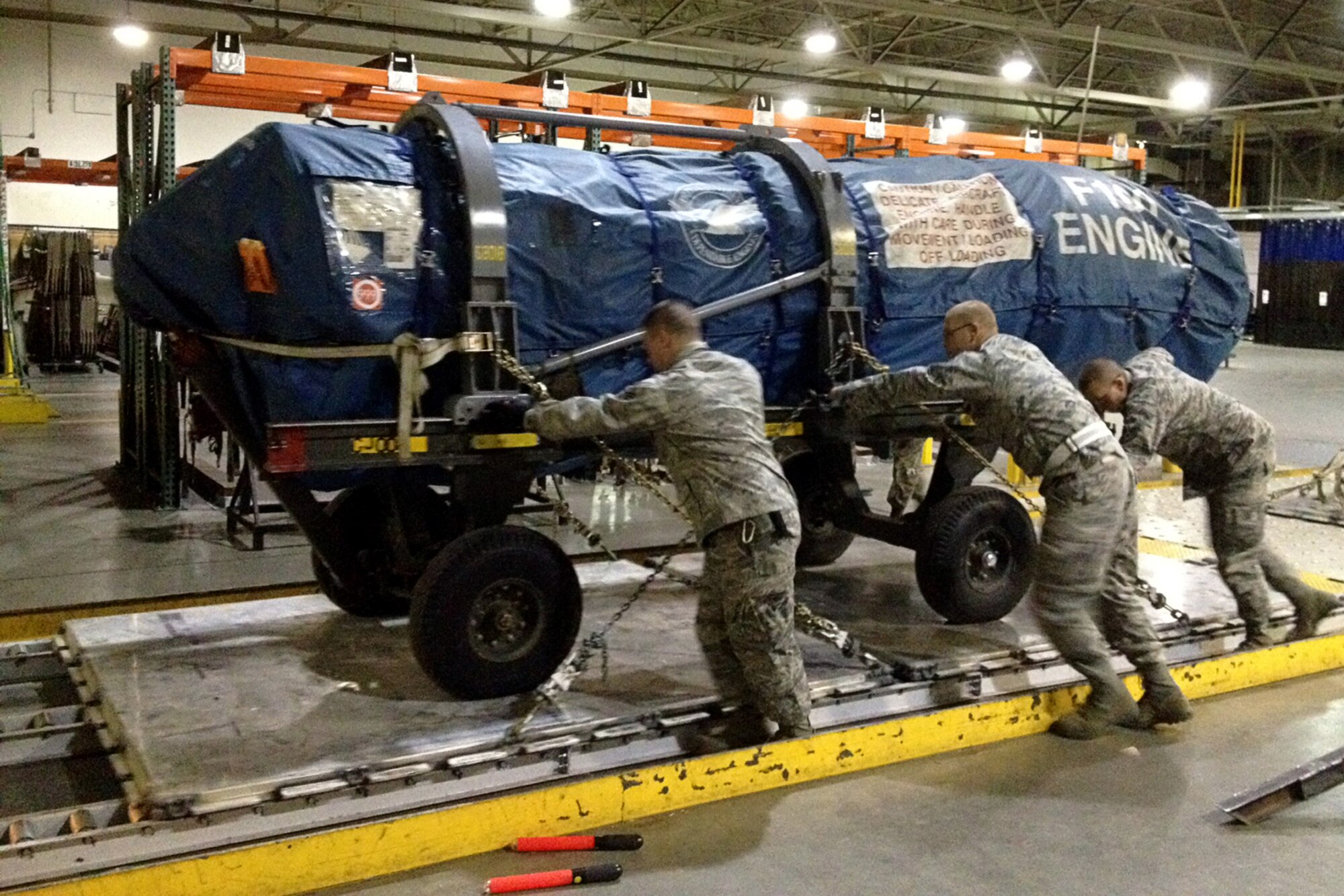 GRISSOM AIR RESERVE BASE, Ind. -- Senior Airman Justin Tuell, Staff Sgt. David Lapprad and Senior Airman Curtis Tillery, 49th Aerial Port Flight apprentices, prepare to load an aircraft engine aboard a jet during a recent annual tour training trip to Joint Base Elmendorf-Richardson, Alaska. (U.S. Air Force photo/Tech. Sgt. Bradley Frank)