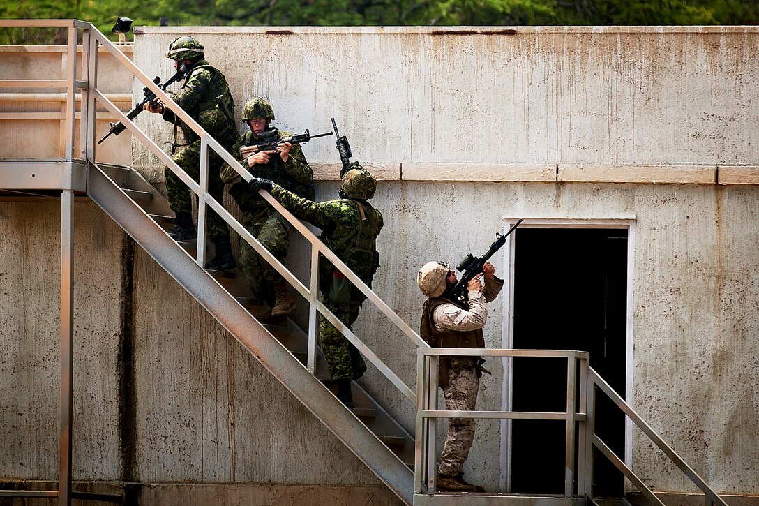 Soldiers from Company A, 2nd Battalion, Princess Patricia's Canadian Light Infantry, and a Marine from 1st Battalion, 3rd Marine Regiment move in as a fireteam to clear a roof top during a Military Operations on Urban Terrain exercise at Marine Corps Training Area Bellows on July, 6. Approximately 2,200 personnel from nine nations are participating in RIMPAC 2012 as part of Special Purpose Marine Air-Ground Task Force 3, Combined Force Land Component Command. The CFLCC is conducting amphibious and land-based operations in order to enhance multinational and joint interoperability. Twenty-two nations, more than 40 ships and submarines, more than 200 aircraft and 25,000 personnel are participating in RIMPAC exercise from June 29 to Aug. 3, in and around the Hawaiian Islands. The world's largest international maritime exercise, RIMPAC provides a unique training opportunity that helps participants foster and sustain the cooperative relationships that are critical to ensuring the safety of sea lanes and security on the world's oceans. RIMPAC 2012 is the 23rd exercise in the series that began in 1971.