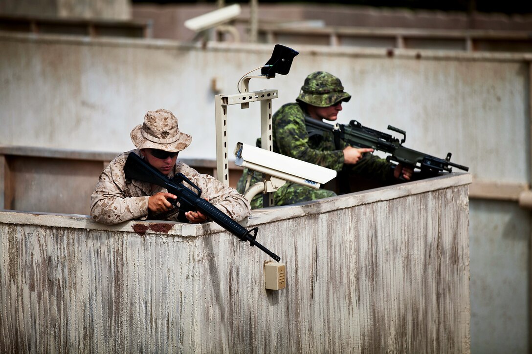 A Soldier from Company A, 2nd Battalion, Princess Patricia's Canadian Light Infantry, and a Marine from 1st Battalion, 3rd Marine Regiment provide security on a roof top during a Military Operations on Urban Terrain exercise at Marine Corps Training Area Bellows on July, 6. Approximately 2,200 personnel from nine nations are participating in RIMPAC 2012 as part of Special Purpose Marine Air-Ground Task Force 3, Combined Force Land Component Command. The CFLCC is conducting amphibious and land-based operations in order to enhance multinational and joint interoperability. Twenty-two nations, more than 40 ships and submarines, more than 200 aircraft and 25,000 personnel are participating in RIMPAC exercise from June 29 to Aug. 3, in and around the Hawaiian Islands. The world's largest international maritime exercise, RIMPAC provides a unique training opportunity that helps participants foster and sustain the cooperative relationships that are critical to ensuring the safety of sea lanes and security on the world's oceans. RIMPAC 2012 is the 23rd exercise in the series that began in 1971.